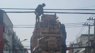 Man klimt op metershoge lading pick-uptruck Thailand