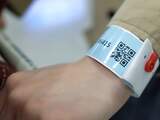 Een reiziger draagt een polsbandje met een QR-code na aankomst op de internationale luchthaven van Hongkong. Inkomende reizigers moeten de QR-code scannen en koppelen aan een app om de verplichte twee weken quarantaine als gevolg van het coronavirus te monitoren.