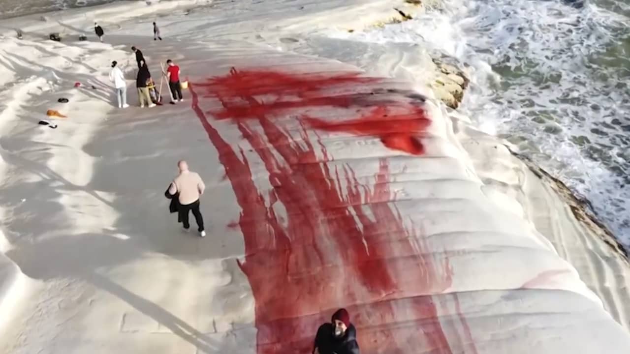 Beeld uit video: Vrijwilligers maken met rode poeder besmeurde klif op Sicilië schoon