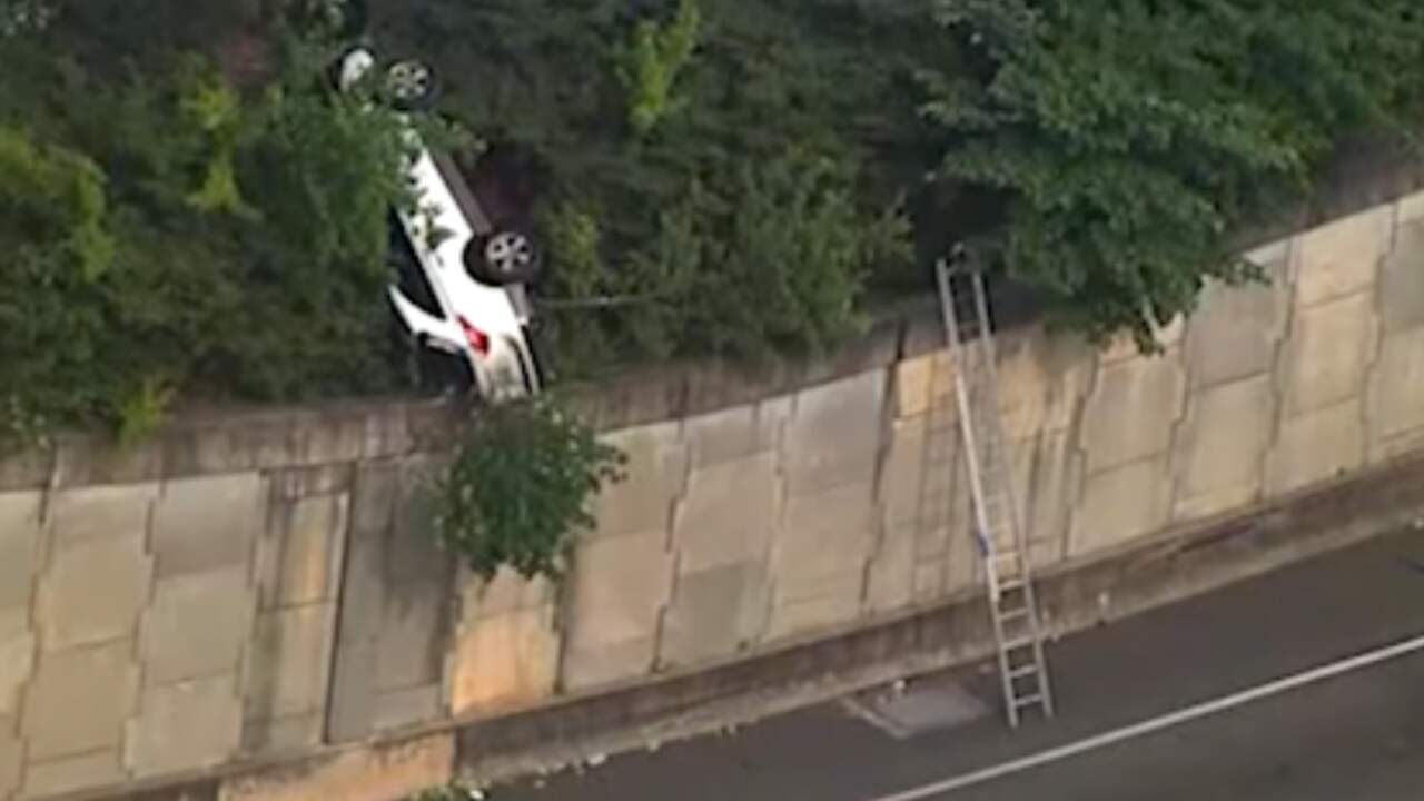 Achtervolgde auto balanceert op muur boven weg in Atlanta