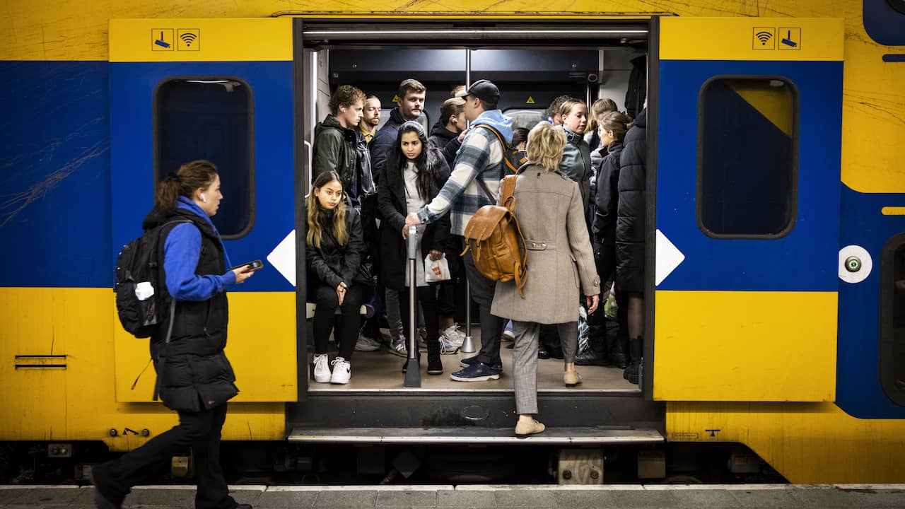 Travelers try to take their seats on a full train during the morning rush hour on 11 October at Utrecht Central Station.