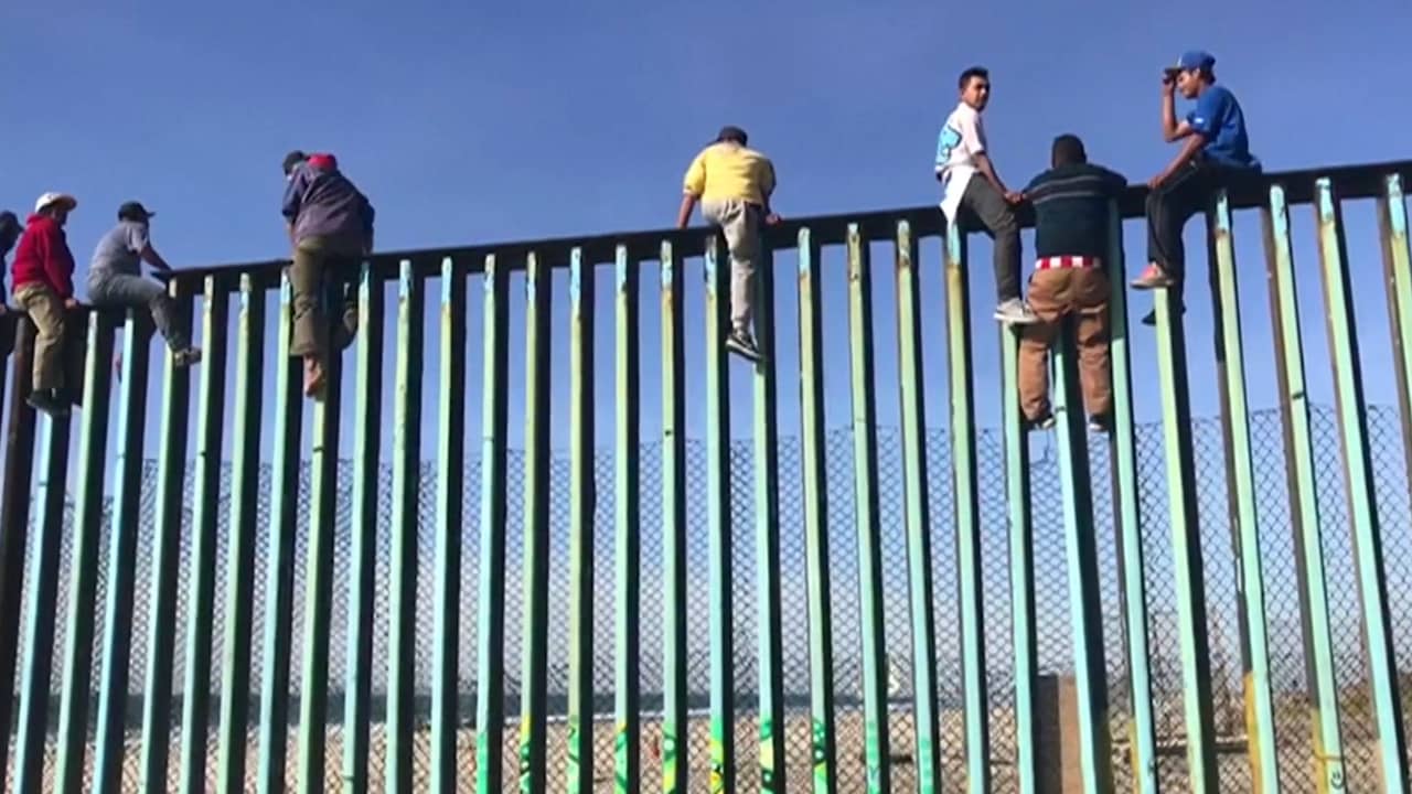 Beeld uit video: Eerste migranten bij Amerikaanse grens klimmen in hekken