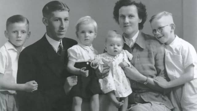 Foto van het gezin De Jonge. Man in pak is vader Andries, Freek staat uiterst rechts.