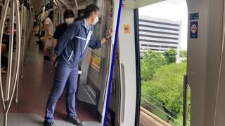 Monorail rijdt met geopende deuren door Bangkok