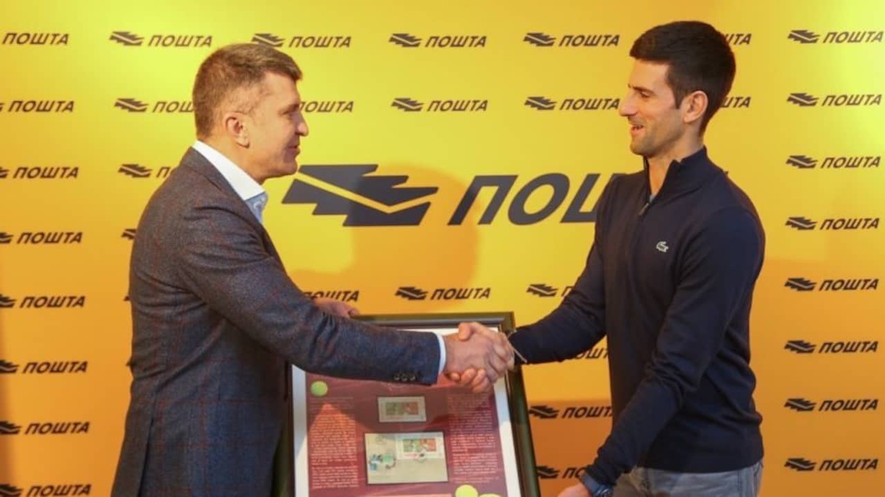 Op de dag waarop hij positief test, neemt Novak Djokovic in Servië zijn eigen postzegel in ontvangst.
