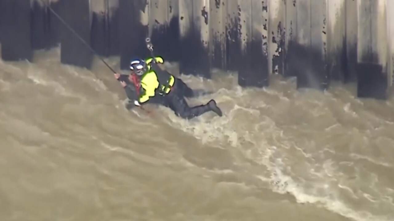 Beeld uit video: Hulpdiensten hijsen man uit snelstromend water in Los Angeles