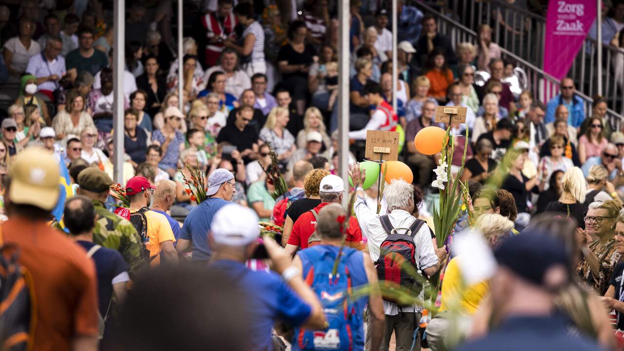 People in stands along the entry cheer the incoming participants.  In total there are more than a hundred thousand spectators.