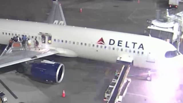 Passagiers staan op vliegtuigvleugel na brandevacuatie in VS