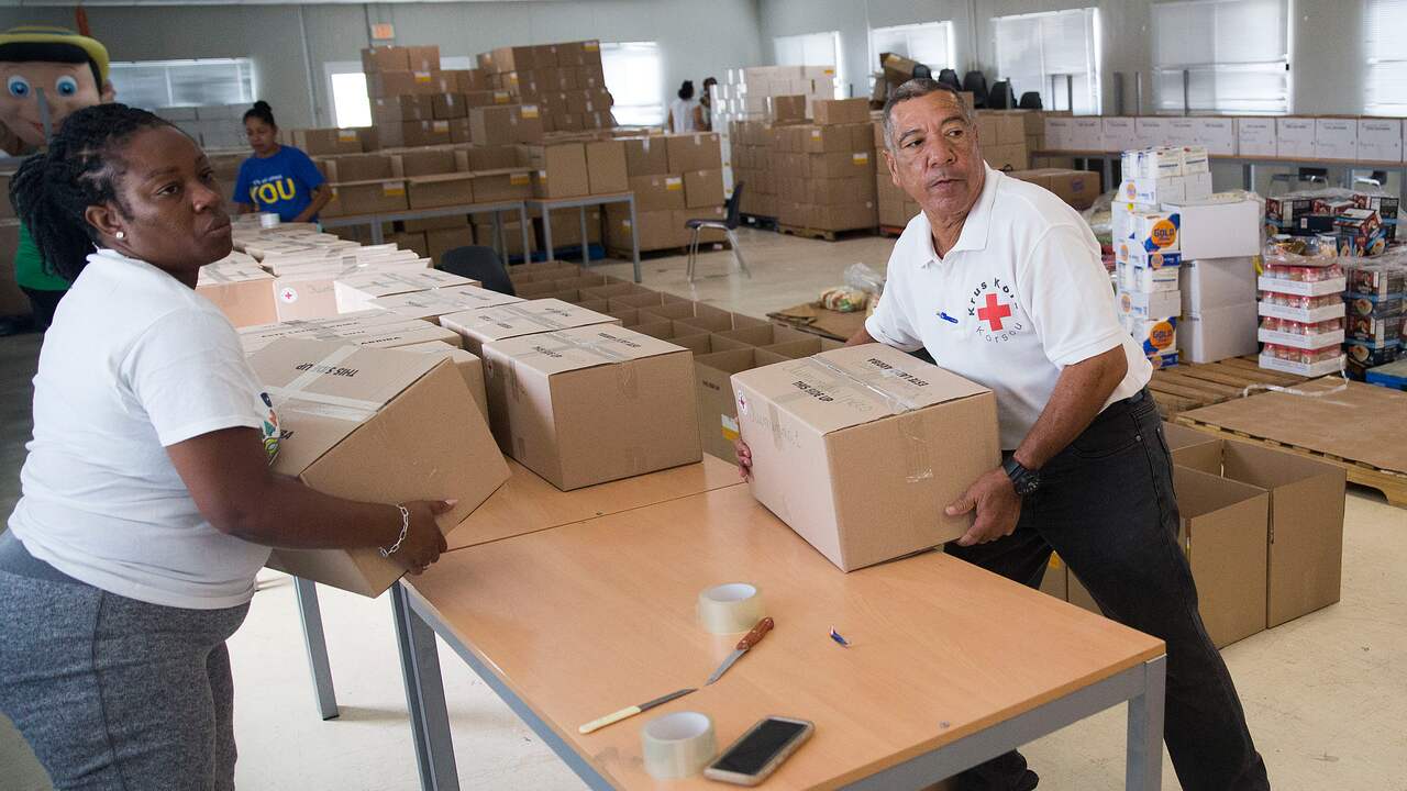 Vrijwilligers van het Rode Kruis vullen hulppakketten voor mensen die hun baan zijn kwijtgeraakt.
