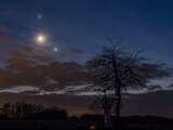 Die twee heldere bollen naast de maan zijn geen sterren, maar Venus en Jupiter