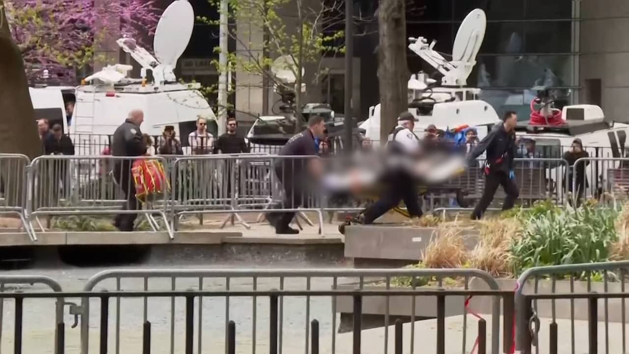 Beeld uit video: Man op brancard weggevoerd na zelfverbranding bij Trumps rechtzaak