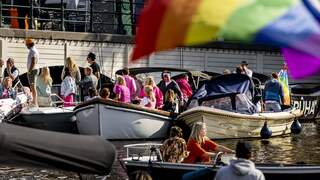 Boten van Canal Parade varen door de Amsterdamse grachten
