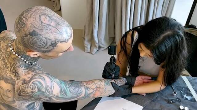 Beeld uit video: Kourtney Kardashian tatoeëert vriend Travis Barker