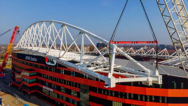 Met twee grote kranen werd een loodzware dakconstructie op de hoofdtribune van het AFAS Stadion gehesen.
