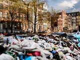 Donderdag  28 april: Schoonmaakploegen storten het afval van Koningsdag in een grote stortschuit aan de Singel in Amsterdam. 
