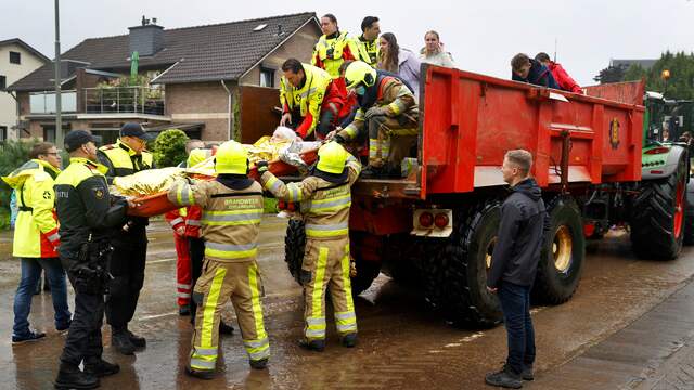 Brandweerlieden helpen met de evacuatie van een bewoner van Valkenburg.