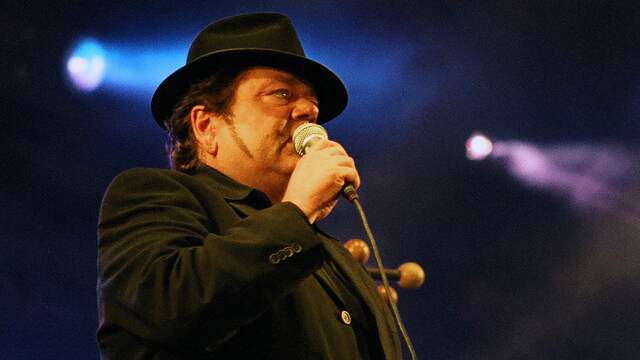 André Hazes in zijn karakteristieke zwarte kleding en met zwarte hoed die hij aan het eind van zijn carrière droeg.