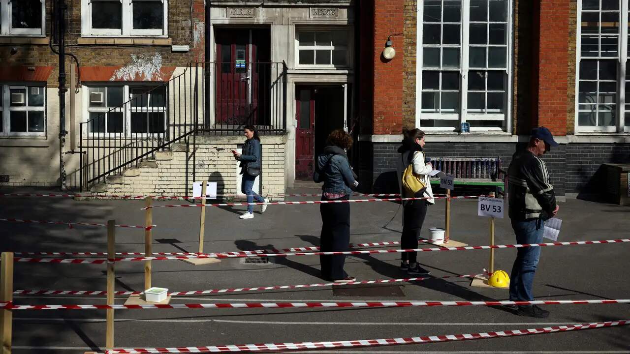 Des lignes prudentes se forment à l'extérieur des bureaux de vote.