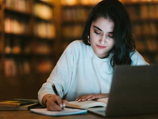 Vrouw studeert achter laptop