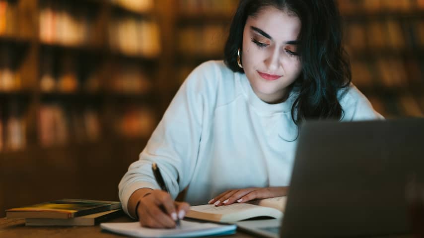 Vrouw studeert achter laptop