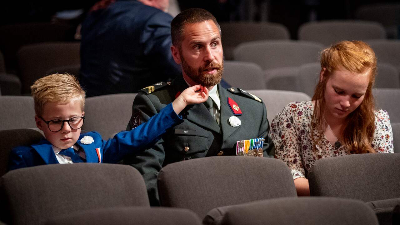 Een veteraan met twee van zijn kinderen tijdens de Nederlandse Veteranendag in de Koninklijke Schouwburg. Het jaarlijkse eerbetoon aan alle Nederlandse veteranen vindt ook dit jaar vanwege corona in aangepaste vorm plaats.