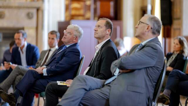 Van Zanen, Prudhomme en Aboutaleb (van links naar rechts) kijken aandachtig naar de presentatie van de plannen van Rotterdam en Den Haag voor de organisatie van de Tour-start.