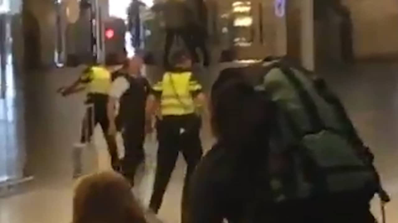 Beeld uit video: Politie houdt dader steekpartij onder schot op Amsterdam CS