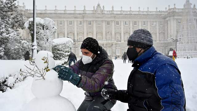 Spanjaarden maken sneeuwpoppen na de storm.