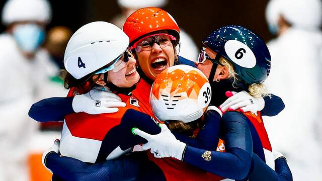 Suzanne Schulting (oranje helm) viert het goud op de vrouwenrelay met haar ploeggenotes.