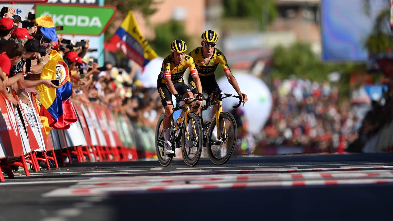 Primoz Roglic crosses the finish line battered, with help from Mike Teunissen.