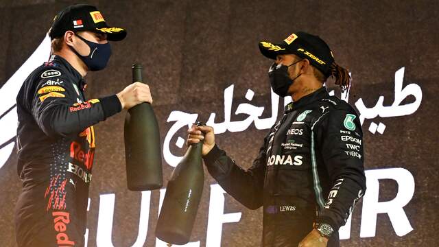Max Verstappen en Lewis Hamilton proosten op het podium in Bahrein.