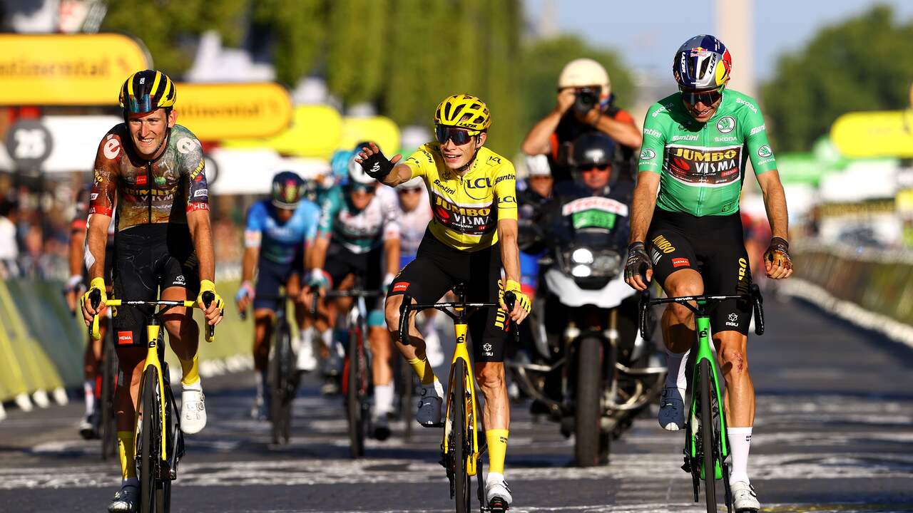 Wout van Aert e os companheiros de equipe Jonas Vingegaard e Tiesj Benoot cruzam a linha de chegada durante a última etapa do Tour de France de 2022.