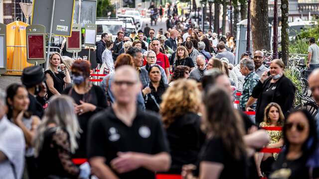 De rij zigzagt over de weg voor het theater, maar is 's ochtends al zo lang dat er een lange lus is ontstaan.