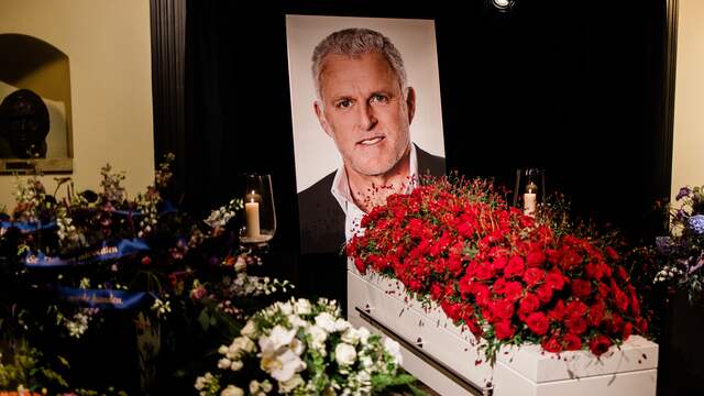 De kist van De Vries wordt omringd door bloemen.