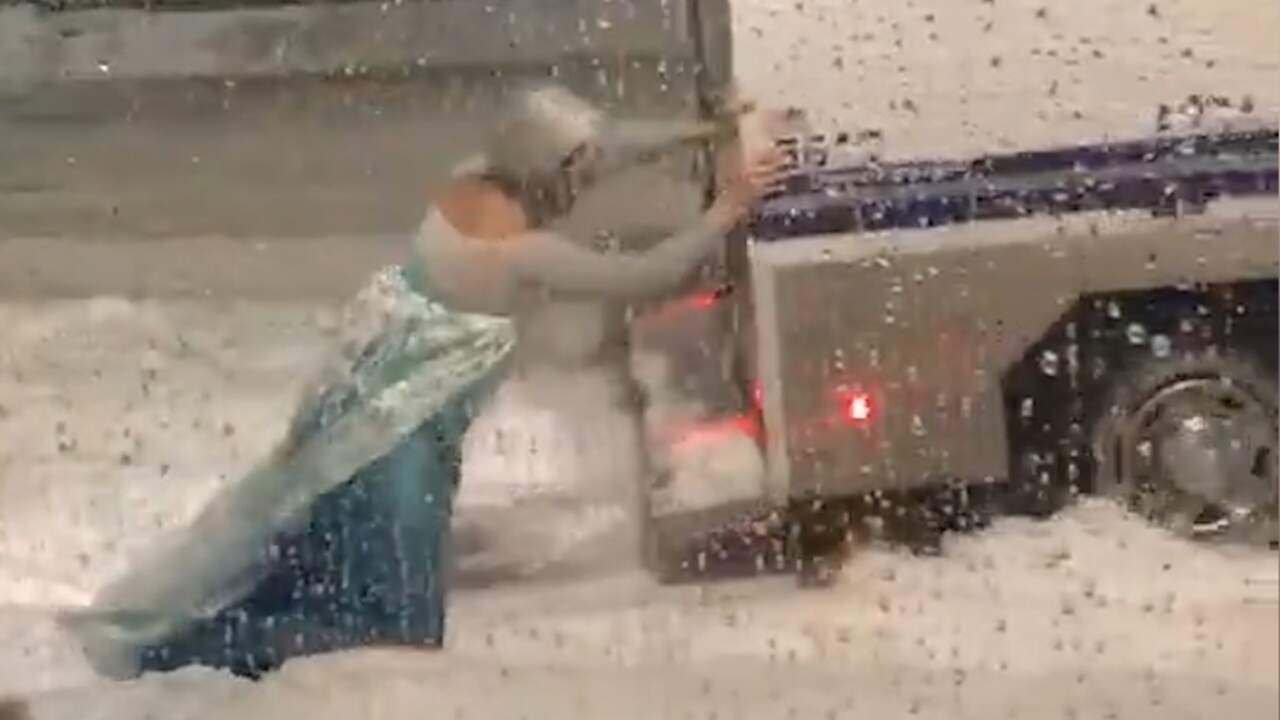 Beeld uit video: Man in 'Frozen'-jurk helpt ingesneeuwde politiewagen