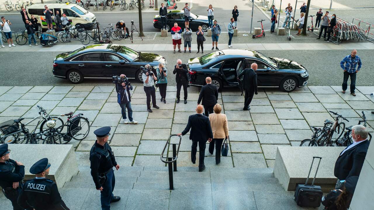 Merkel verlaat het Duitse parlementsgebouw na de laatste zitting voor de verkiezingen op 7 september. Te zien is hoe ze wordt begeleid door haar lijfwachten.