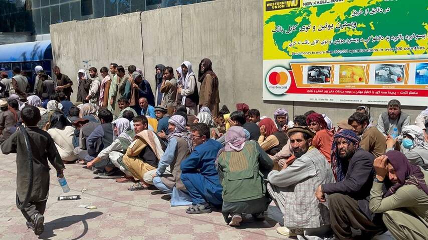 Afghanen wachten in lange rijen bij een bank in de Afghaanse hoofdstad Kaboel om geld op te nemen.