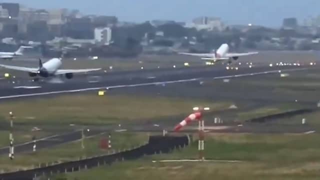 Vliegtuig landt op landingsbaan waar een ander toestel net opstijgt