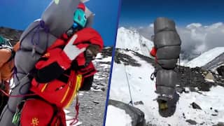 Nepalese gids tilt onderkoelde klimmer op rug Mount Everest af