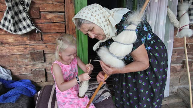 Dochtertje van Yvonne mag proberen wol te spinnen.