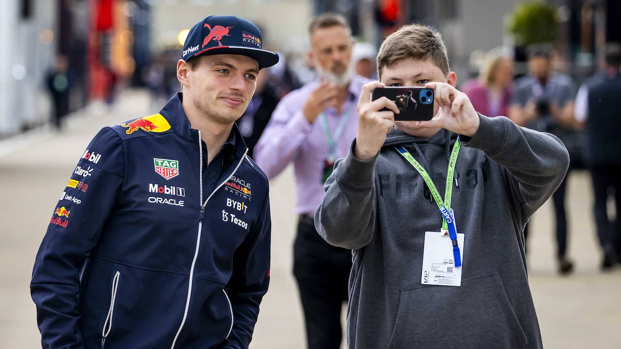 Max Verstappen has his picture taken with a fan at the Silverstone circuit.