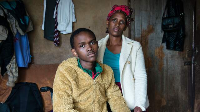 De door kogels verlamde Machawe Lukhuleni samen met zijn moeder Thembile Groening in hun huisje in Lomahasha in Eswatini.