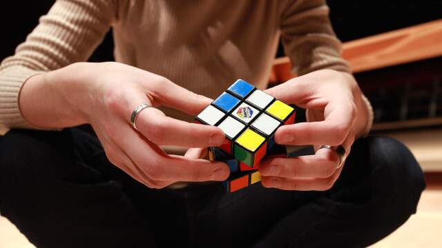 Een Rubiks kubus. Als je het ene vlakje verschuift, dan verschuift er ook meteen een ander vlakje.