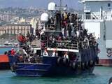 Migranten juichen terwijl boot Italiaanse haven in wordt gesleept
