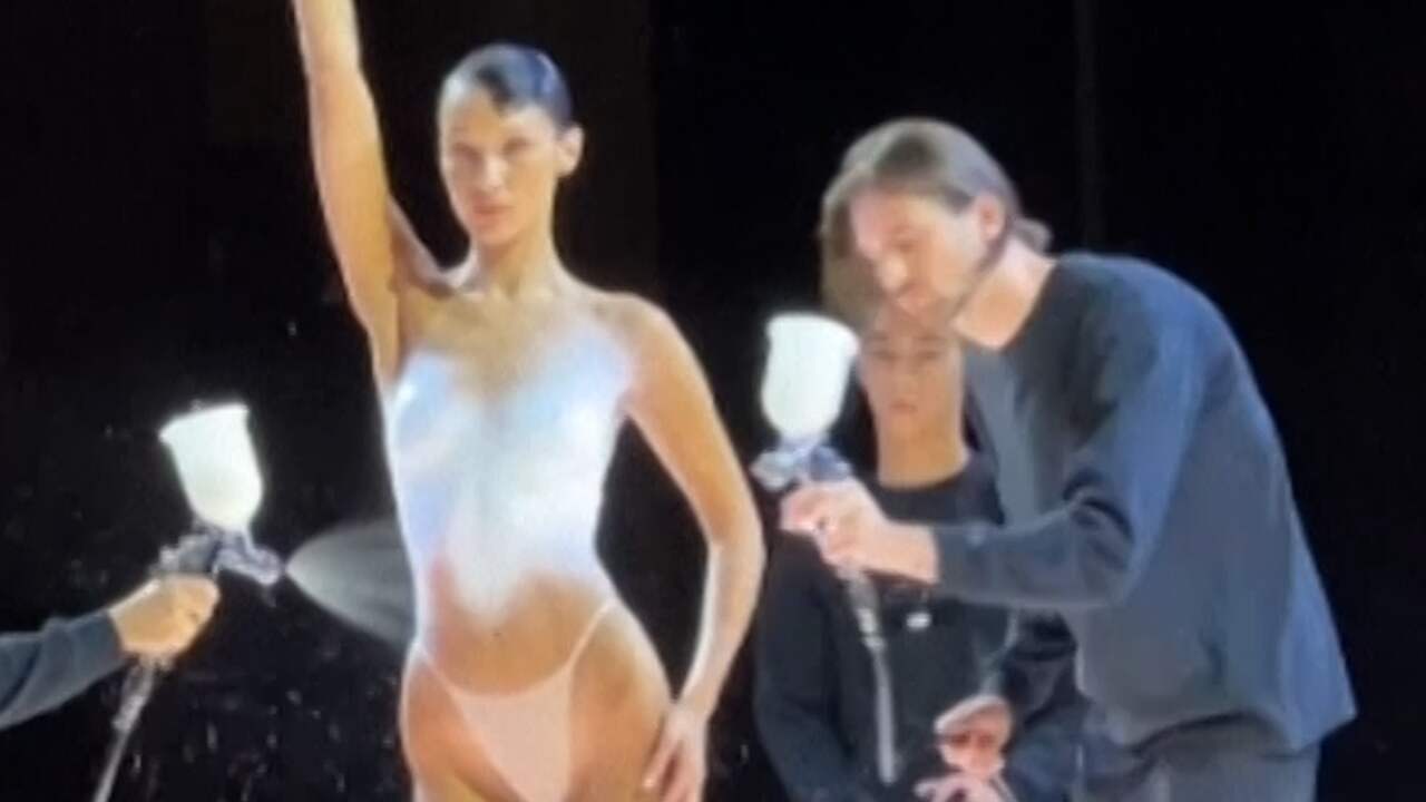 Beeld uit video: Bella Hadid loopt topless catwalk op en krijgt live een jurk van verf