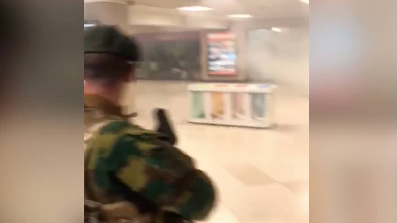 Militairen lopen door rook in leeg station Brussel na explosie