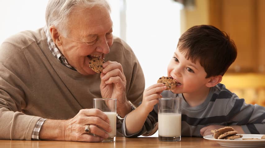 Opa en kleinzoon eten koekjes en melk