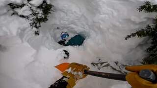 Amerikaanse skiër graaft onder sneeuw bedolven snowboarder uit