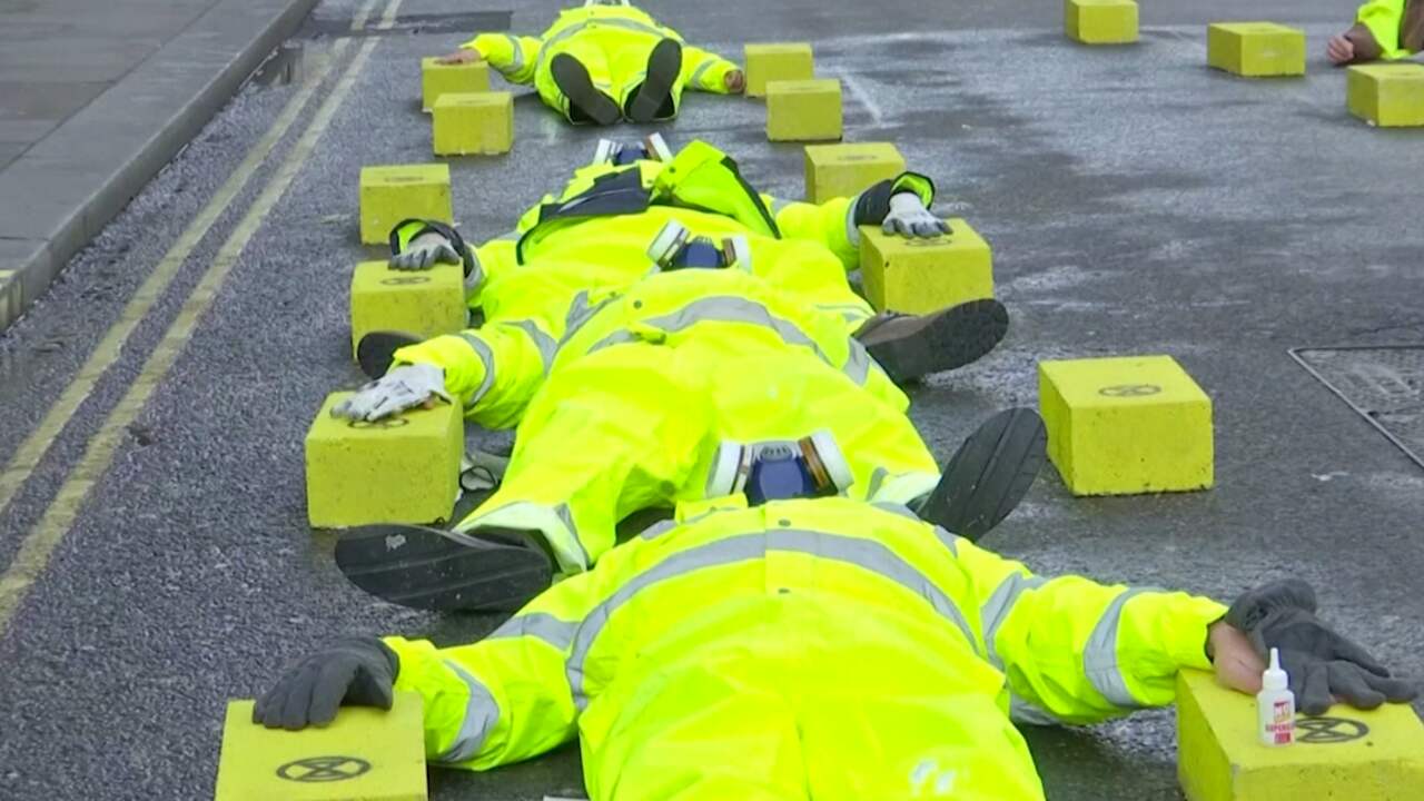 Klimaatactivisten lijmen hand aan wegdek vast in Londen