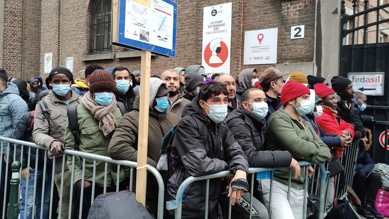 Centinaia di richiedenti asilo aspettano fuori dal centro di richiesta di asilo a Bruxelles.